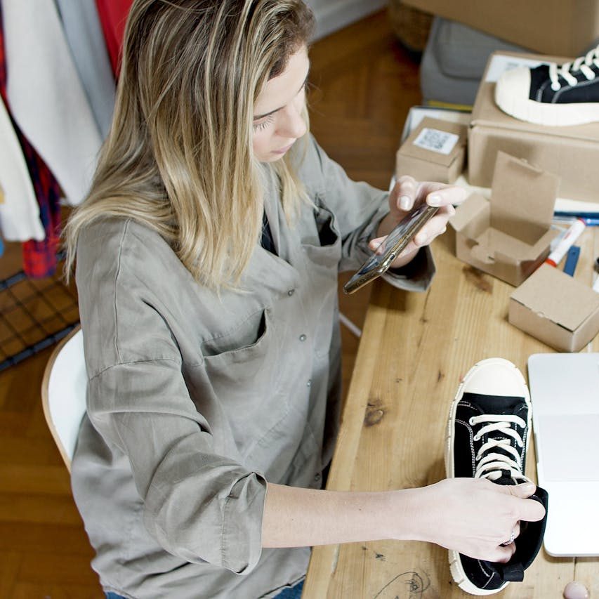 pexels-kampus-7289723 a woman at a desk holding a shoe, possibly a business woman i think she needs a websire audit